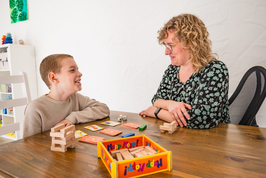 Ein Junge und eine Frau spielen ein Spiel mit Würfeln und Karten